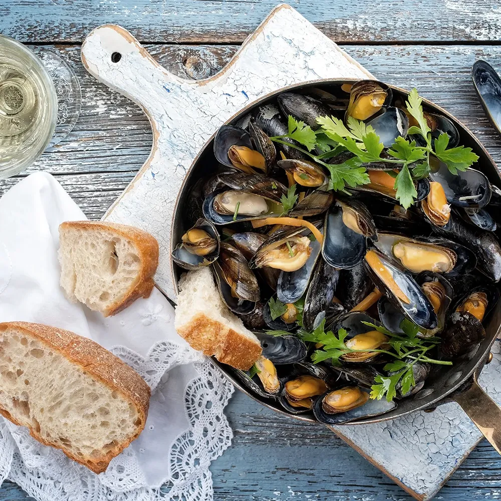 Traditional barbecue mediterranean blue mussel in white wine as top view in a casserole